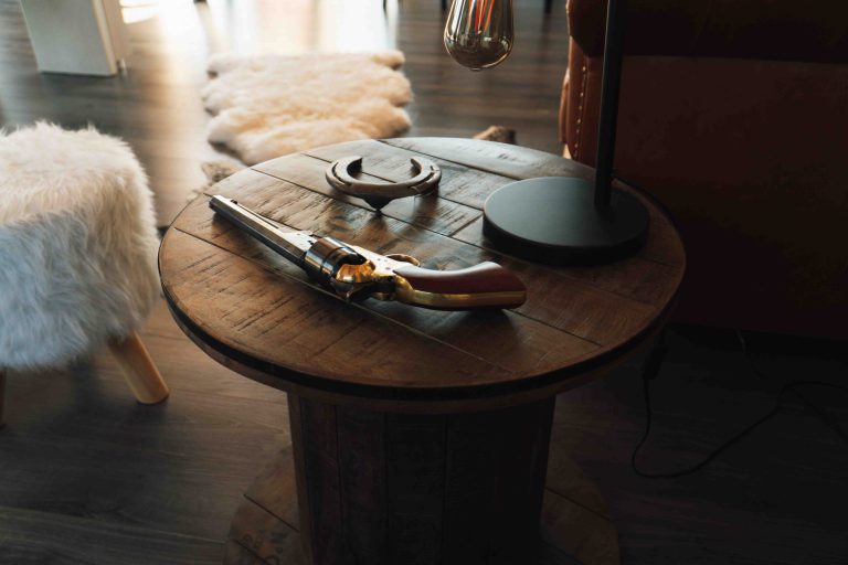 Une table basse avec un pistolet, un fer à cheval et une lampe